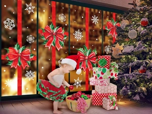 Close-up of reusable Christmas window decals featuring red bows, holly, and white snowflakes
