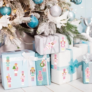 Gros plan d'autocollants casse-noisette pastel décorant des boîtes cadeaux de Noël