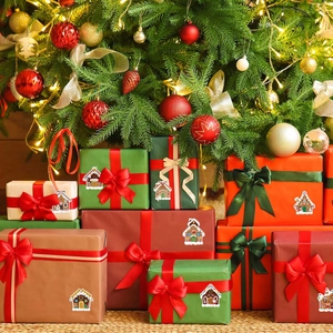 Christmas stickers with gingerbread house designs applied on festive holiday gift boxes