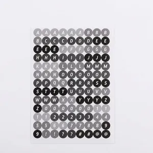 Detail of round monochrome DIY sticker sheet featuring black letters and numbers