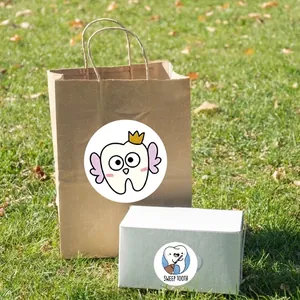 Cute tooth-themed cartoon stickers on paper bag and gift box with outdoor grass background