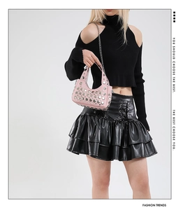 Dettaglio mini borsa rosa con borchie argentate e tracolla a catena in metallo