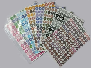 Close-up of colorful round numeric and alphabet stickers for DIY teacher classroom labels