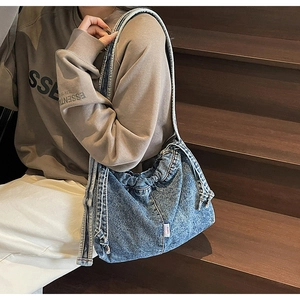 Détail de la texture denim vintage et patch de marque sur le sac fourre-tout décontracté