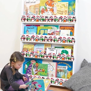 Christmas penguin bulletin board border sticker applied to white bookshelf in nursery