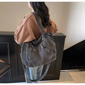 Détail d'un grand sac cabas en denim délavé montrant ses poches latérales pratiques