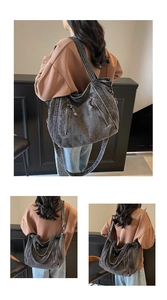 Détails du sac fourre-tout en denim gris lavé avec plusieurs poches zippées en métal