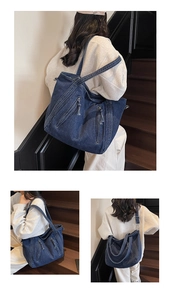 Détail du sac à bandoulière en denim bleu foncé montrant les sangles et la texture du tissu