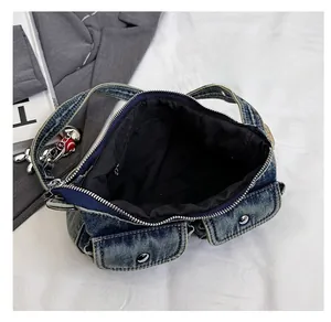 Internal view of denim shoulder bag with black lining, zip pocket, and silver hardware
