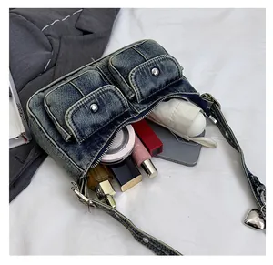 Spacious interior of blue denim shoulder bag showing storage for phone and umbrella