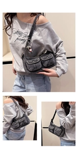 Macro detail of washed black denim baguette bag with flap pockets and heart charm