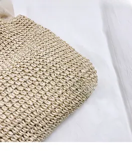 Detailed close-up showing the premium natural cross-woven texture of the straw shoulder bag