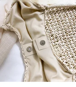 Detailed shot of the straw bag featuring a secure metal magnetic clasp and fabric lining