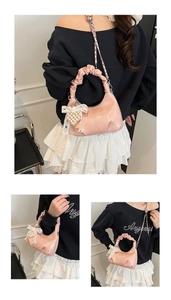 Detail of pink ruched cloud bag featuring pearl heart charm and lace bow accessory