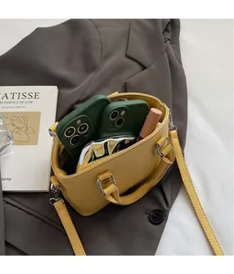 Interior detail of yellow leather bag showing ample space for phones and lipstick