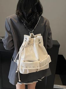 Chic beige glossy bucket backpack with rivet details and silver chains for women
