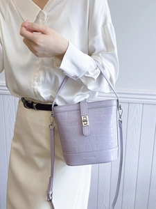 Sac seau violet clair motif crocodile avec fermoir rotatif argenté et bandoulière