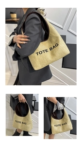 Detailed view of the woven straw tote bag featuring leather handles and black TOTE BAG print