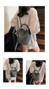 Détail du sac seau noir en cuir grainé avec foulard en soie sur un escalier