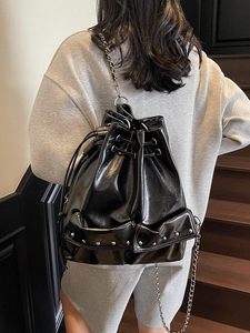 Chic black patent leather bucket backpack with silver studs and chain straps