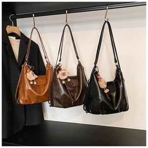 Vue détaillée de grands sacs portés épaule en marron, café et noir avec breloques mouton