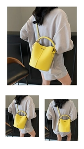 Détail d'un sac seau jaune à motif litchi avec foulard décoratif et bandoulière