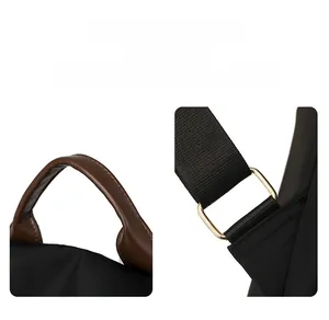 Detail of durable brown leather handle and gold metal hardware on black backpack