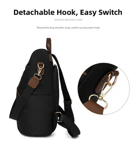 Detail showing detachable gold metal hooks and adjustable strap for black nylon backpack