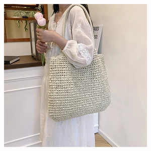 Detail of hand-woven straw tote bag with textured straps and natural bohemian fiber weave