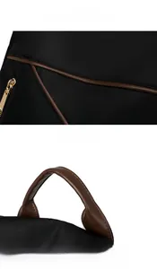 Detail view of smooth brown leather handle and gold zipper on a black nylon backpack