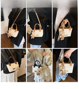 Borsa tote in paglia con manici in pelle marrone e ciondolo orsetto in diverse viste lifestyle