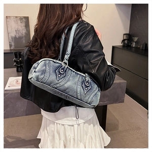 Detailed back view of a light blue washed denim Boston bag with chic rivets and stitching