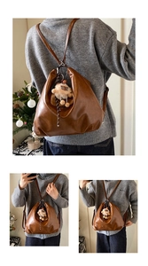 Détail d'un sac à dos vintage en cuir marron avec un joli porte-clés alpaga en peluche