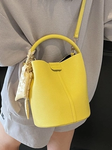 Sac seau jaune motif litchi avec détails plissés et charm foulard en soie