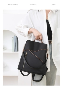 Chic black nylon backpack for women featuring asymmetrical zippers and brown leather trim