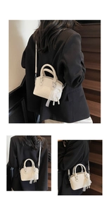 Detail of off-white lychee texture bucket bag with elegant lace pearl charm and straps
