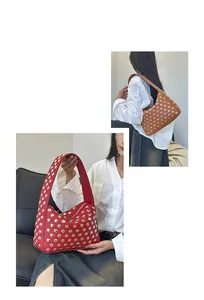 Detail view of red and brown studded shoulder bags with metallic rivets and pebbled leather