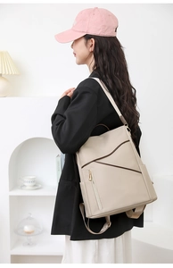 Close-up of beige minimalist soft leather backpack with side pockets and smooth zippers