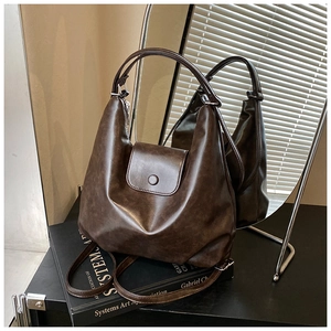 Détail d'un sac cabas en similicuir marron foncé avec rabat magnétique et texture