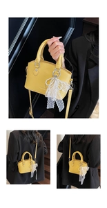 Detail of yellow litchi pattern bag with pearl bow and lace charm accessory