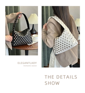 Detail of hobo bag with silver metallic eyelets and rivets in black and off-white