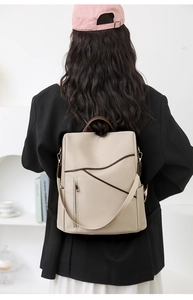 Detailed view of cream soft leather backpack with contrast trim on a model