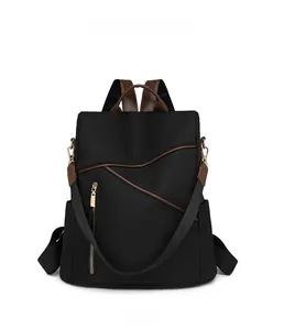 Front view detail of black waterproof nylon backpack with brown faux leather trim and zippers