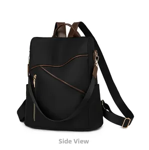 Side view of a black nylon backpack featuring brown leather trim and golden zippers