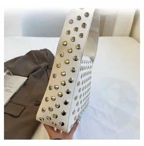 Detail view of white lychee leather shoulder bag with decorative silver metal rivets