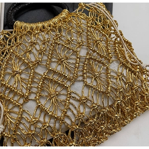 Detail der goldenen gewebten Strandtasche mit Blumenmustern und Kordelzug-Innentasche