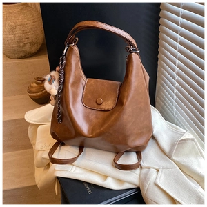 Vue détaillée d'un sac hobo vintage en cuir marron souple avec charm sur un blazer