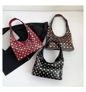 Close-up of punk-style hobo bags in red, brown, and black with metallic rivet details