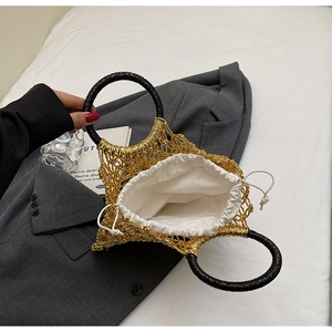 Detail der goldenen gewebten Strandtasche mit schwarzen Rundgriffen und Kordelzugfutter