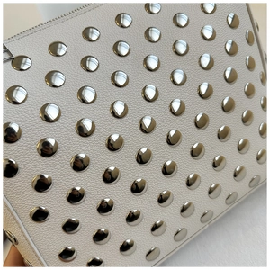 Detailed macro view of white lychee leather texture with silver metal studs and zipper